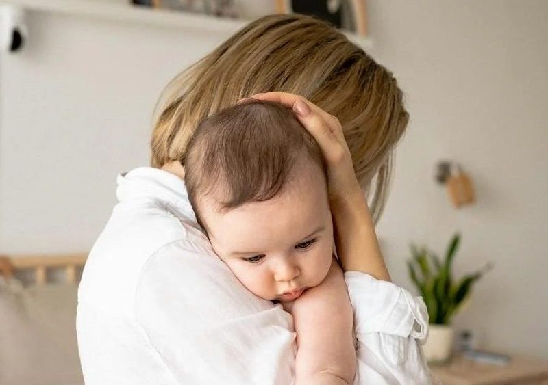 brown haired woman holding a brown haired baby. Perinatal mood disorders. postpartum anxiety and depression treatment draper utah. postpartum therapy draper utah. postpartum therapy utah.