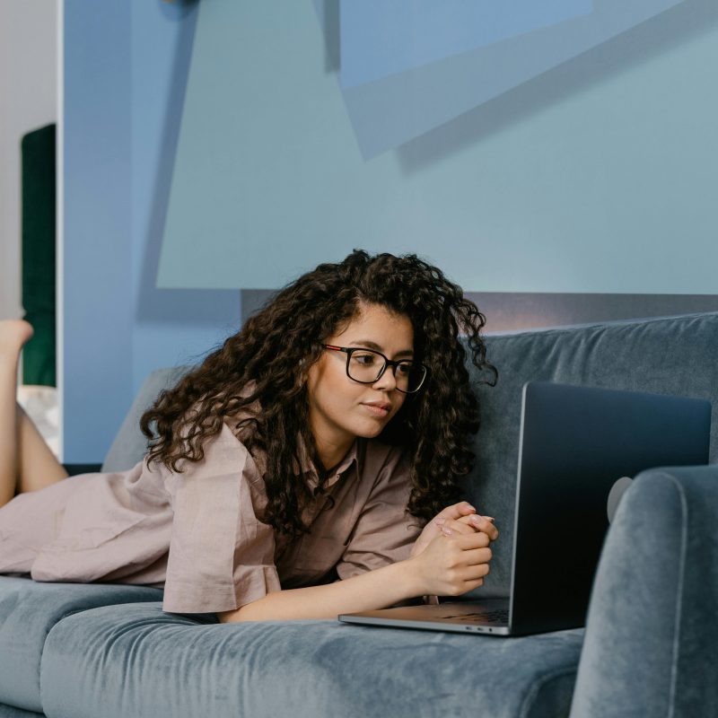 woman laying on the couch looking at a computer. therapy in utah. therapy utah. Empower You Therapy. empowering you therapy. therapist draper, self-worth while battling with Breast Cancer